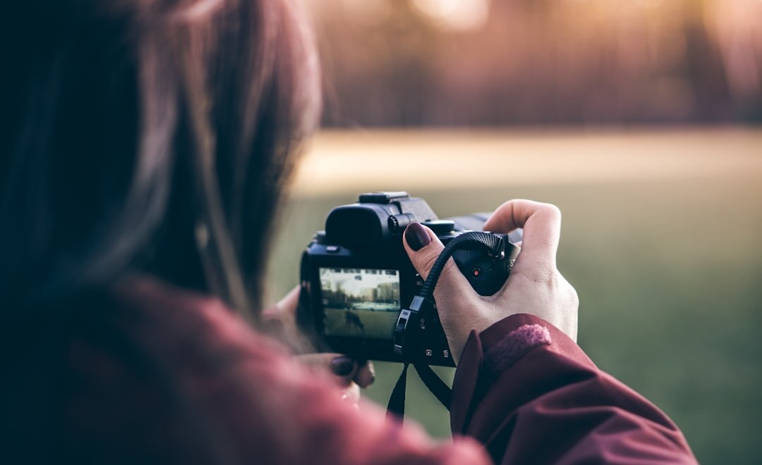 Photographer adjusting camera lens outdoors